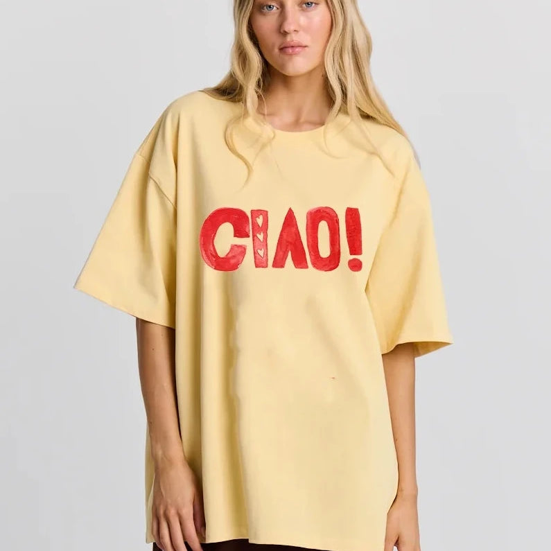 Person wearing a yellow oversized t-shirt with 'CHAO!' text on a plain background
