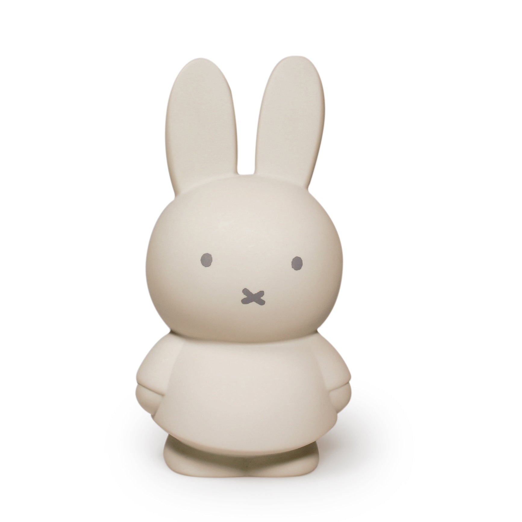 A minimalist rabbit figurine in a warm off-white or cream color, featuring simple gray eyes and a small stitched mouth, set against a solid white background.